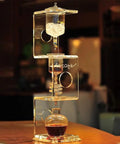 Topnotch Cold Brew Coffee Maker With Slow Drip Ice Tank And Large Capacity Glass Carafe On Solid Wood Base for smooth home coffee brewing.