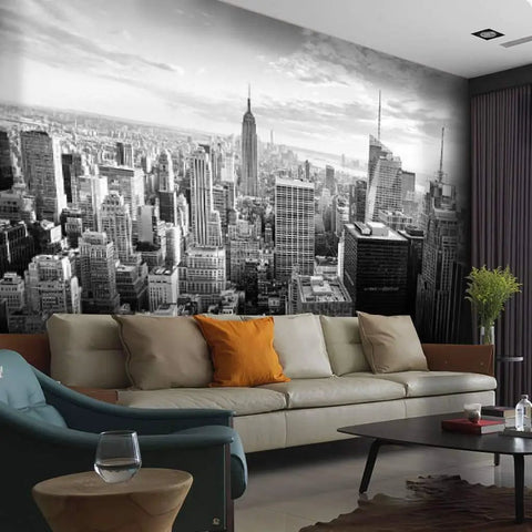 Black-and-white living room with New York City Skyline Canvas Wall Mural in background, self-adhesive peel and stick, modern urban decor.