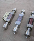 Three waterjet intensifier assemblies with silver housings and red/purple internal tubes.