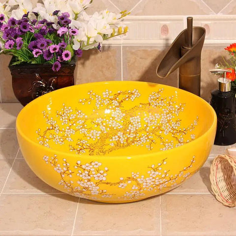 Top Tier Yellow Floral Ceramic Vessel Sink For Bathroom Countertop Featuring Handmade Artistry Slick Craftsmanship No Fuss Install With Center Drain And Fresh Vibes To Level Up Your Bathroom. Round ceramic vessel sink with bright yellow finish and floral design.