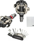 Assioma Pro MX 1 Single Sided Power Meter Pedals For MTB And Gravel With Bluetooth And ANT Plus Data Dope Precision Durable Rechargeable Spindle Left Pedal Watt Meter That Doubles Total Power Includes Handy Multi Tool Kit with multi-tool and pedal cloth visible.
