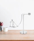 Dope Newton Pendulum Desk Decor With Surfing Or Skiing Little Man Figurines on a wooden desk, metal construction