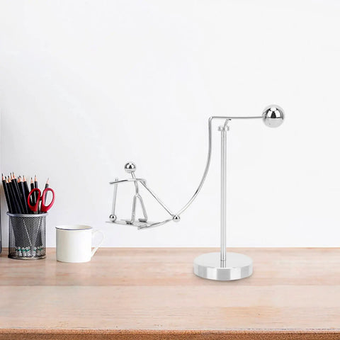 Dope Newton Pendulum Desk Decor With Surfing Or Skiing Little Man Figurines on a wooden desk, metal construction
