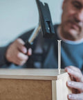 Built Tough Double Head Skirting Nails 200 Piece Pack seamless coil fasteners being hammered into wood for trim installation.