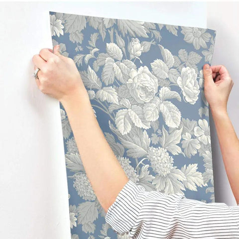 Person installing French Antique Floral Removable Wallpaper in Wedgwood blue gray and white, double roll set, easy install