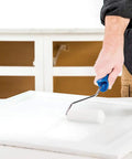 Person using Cabinet Coat Urethane Acrylic Satin Enamel Paint for Cabinets White 1 Gallon on kitchen cabinet with roller brush