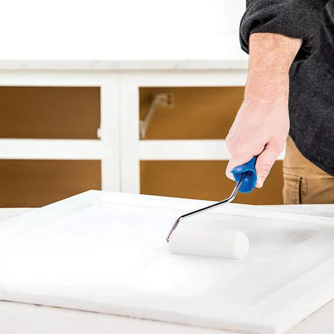 Person using Cabinet Coat Urethane Acrylic Satin Enamel Paint for Cabinets White 1 Gallon on kitchen cabinet with roller brush