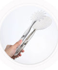 Hand holding stainless steel frying tongs with strainer