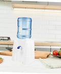 Tabletop Water Dispenser Cooler For Home Office And Outdoor Use on kitchen countertop with bottled water