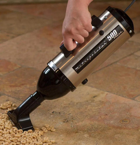 VM6SB500 500W 120V High Performance Hand Vacuum With All Steel Build And Beastly Suction in use on a tile floor with cereal
