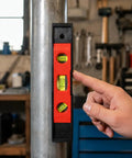 Spirit Level, 3, New Yellow Level 23CM shown against a metal pole with a hand pointing at the bubble vials for leveling.