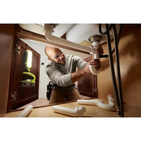 One Plus Hybrid LED Project Light With 900 Lumens illuminating workspace under the sink during plumbing work