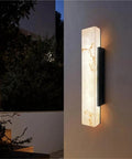 Modern Linear Wall Sconce Imitated Marble LED Wall Light,Warmth mounted on a wall with warm light illuminating a textured surface.