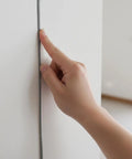 Hand pressing 1/4 inch foam strip backer rod into a wall gap, demonstrating the Grab This Cool 26 Ft Backer Rod For Your DIY Projects!