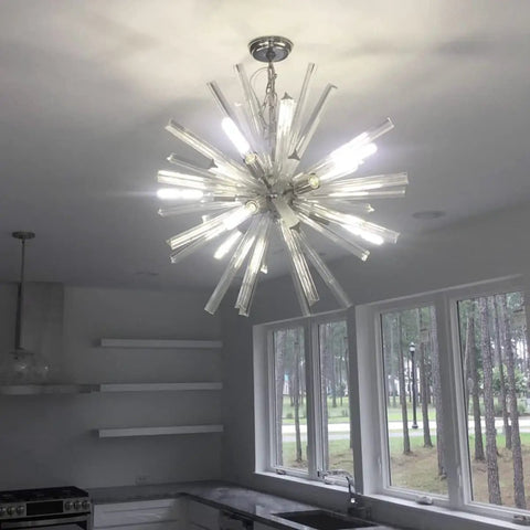 Chandelier in modern kitchen, decorative lighting, kitchen decor, glass and metal fixture, windows with forest view, bright room.