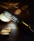 Dimmable T10 Edison LED Tubular Bulb 4000K Daylight White Dope Vintage Filament Light 60W Equivalent E26 Base glowing on wood