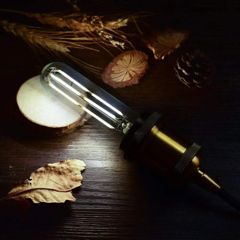 Dimmable T10 Edison LED Tubular Bulb 4000K Daylight White Dope Vintage Filament Light 60W Equivalent E26 Base glowing on wood