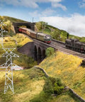 Totally Legit N Scale 1 160 Miniature Electric Transmission Tower in model railroad scenery with trains and landscape.