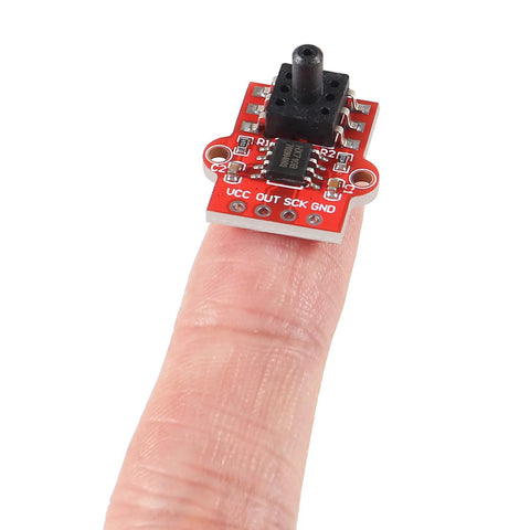 Close-up of red DWEII air pressure sensor module board on fingertip, showing VCC OUT SCK GND pins