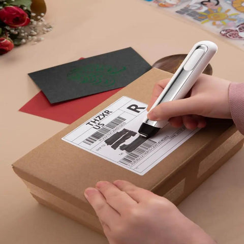 Person using Your Go To 4 In 1 Mini Heat Press Kit With 3 Second Fast Heating to erase label on a cardboard box