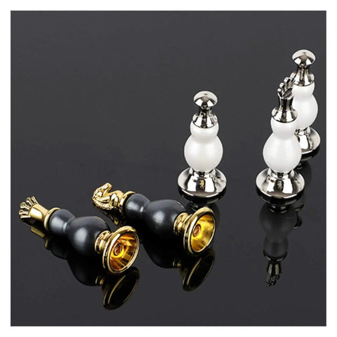 Elegant metal and pearl chess pieces on glossy black surface, showcasing intricate design and craftsmanship in chess set.