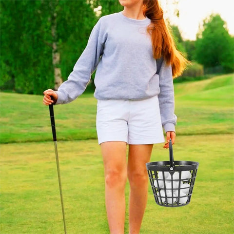 Person holding a Golf Ball Basket With Handle Holds Up To 25 Balls Plastic Ball Container Black For Outdoor Practice.