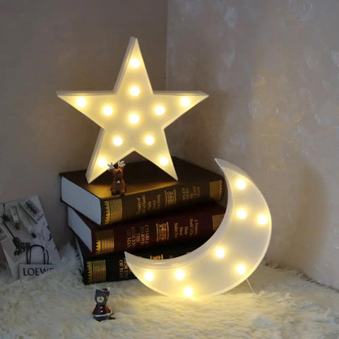Star Shaped LED Marquee Light With 11 Warm White LEDs, Battery Operated By 2 AA, on books, next to a glowing moon light