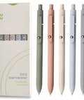 Five Pack Gel Pens 0.5mm Fine Point Black Ink With Super Soft Grip For Smooth Writing Ideal For Journaling And Note Taking Everyday Office School Supplies Gift For Women And Men Morandi Color Set next to packaging