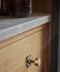 Top Shelf Antique Brass Cabinet Knobs With Quatrefoil Backplate on wood drawer, featuring a round rotary knob and quatrefoil design.