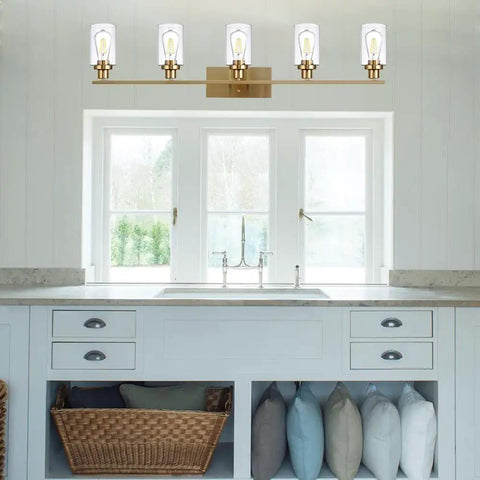 Cool Five Light Brushed Brass Vanity Light Fixture With Clear Glass Shades Mounted Above Bathroom Sink