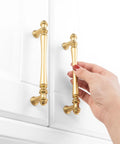 Person holding 10 Pack 5 Inch Brushed Gold Kitchen Cabinet Handles And Drawer Pulls For Cabinets Dresser Cupboard Bedroom And Bathroom Furniture Hardware P30 Style Solid Metal Construction French Style Smooth Rounded Corners