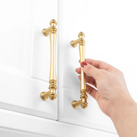Person holding 10 Pack 5 Inch Brushed Gold Kitchen Cabinet Handles And Drawer Pulls For Cabinets Dresser Cupboard Bedroom And Bathroom Furniture Hardware P30 Style Solid Metal Construction French Style Smooth Rounded Corners