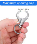 Close-up of a silver metal trigger snap hook with swivel ring, held by fingers.