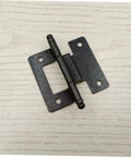 Black heavy duty cabinet hinges on white wood surface