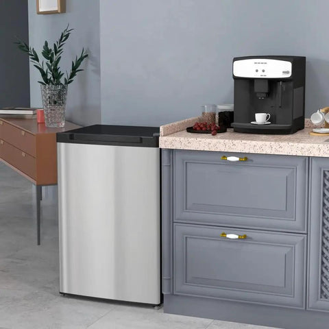 Compact Upright Mini Freezer With 3.0 Cubic Feet Capacity And Reversible Door For Dorm Life Apartments Rv Trips And Office Setups next to a coffee machine in a modern kitchen.