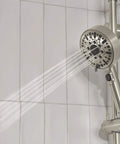 Precept Slide Bar With Brushed Nickel Finish, Easy Dial To Switch Hand Shower Spray Settings, showing water spray on tile wall