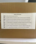 Cardboard box with multilingual safety warning label, advising caution and distance from fire sources.