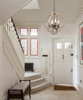 Handmade Wood Farmhouse Orb Chandelier with four lights, openwork quatrefoil frame, hanging in bright entryway.