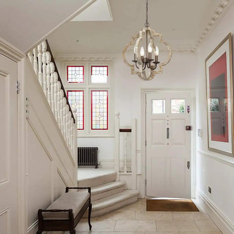 Handmade Wood Farmhouse Orb Chandelier with four lights, openwork quatrefoil frame, hanging in bright entryway.