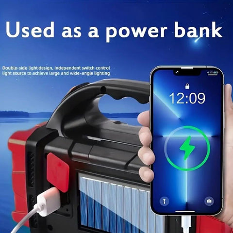 Solar Flashlight With USB C Rechargeable Power Bank in use charging a smartphone outdoors by a lake