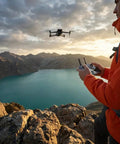 Person operating Air 3S Drone With RC 2 Fly More Bundle For Travel And Content Creation over scenic lake and mountains.