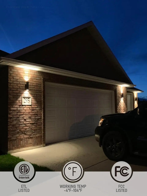 Outdoor Cylinder Wall Lights 12 Inch Up Down Sconce illuminating garage at night, showing matte black weatherproof aluminum fixture
