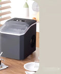 Compact Countertop Ice Maker Crafting Quick Bullet Ice In Six Minutes Flat on kitchen table with coffee and snacks.