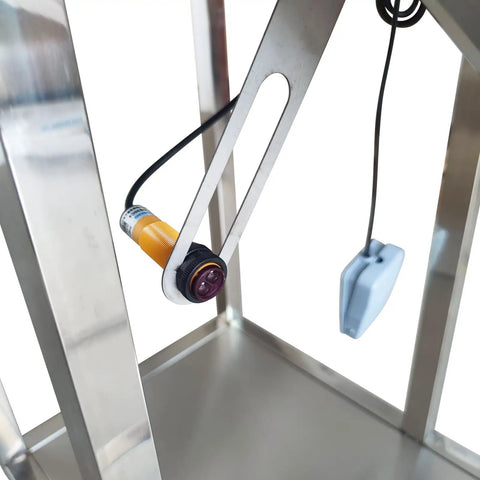 Close-up of automatic stainless steel powder filling machine's infrared sensor for precise measurement.