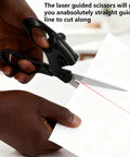 Close-up of professional laser guided scissors with ergonomic black handles cutting white paper; red laser line visible.