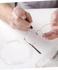 Hands repairing glasses with Eyeglass Repair String For Half Frame Glasses Compact Lightweight Maintenance Tool With Nylon Thread.