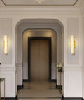 Brushed Brass And Natural Alabaster Wall Sconces Set Of TwoCasting an ambient glow in a modern hallway with elegant decor.