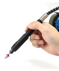 Hand holding detailed tool attachment for Top Shelf Mini Bench Grinder With Quick Adjust Speed Dial for engraving tasks.