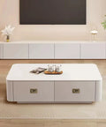 Modern white living room furniture with a coffee table and TV console, wooden flooring, and decorative items, in a minimalist design.