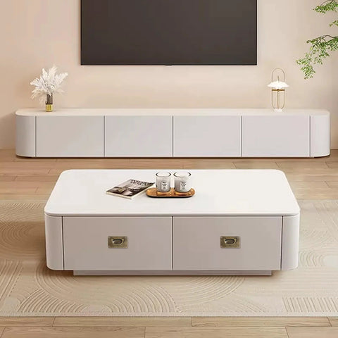 Modern white living room furniture with a coffee table and TV console, wooden flooring, and decorative items, in a minimalist design.
